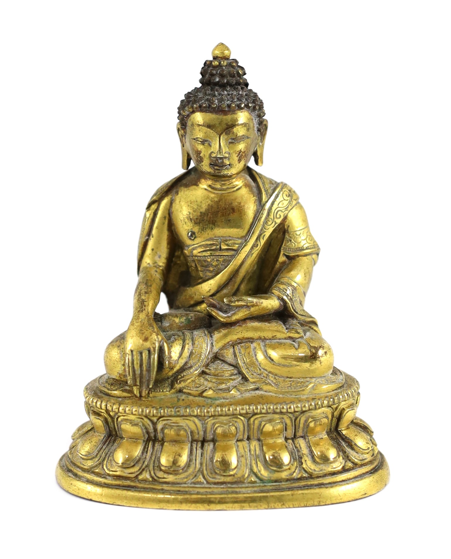 A small Tibetan gilt bronze seated figure of Buddha Shakyamuni, 18th century, 9.5cm high, lacking bowl in left hand